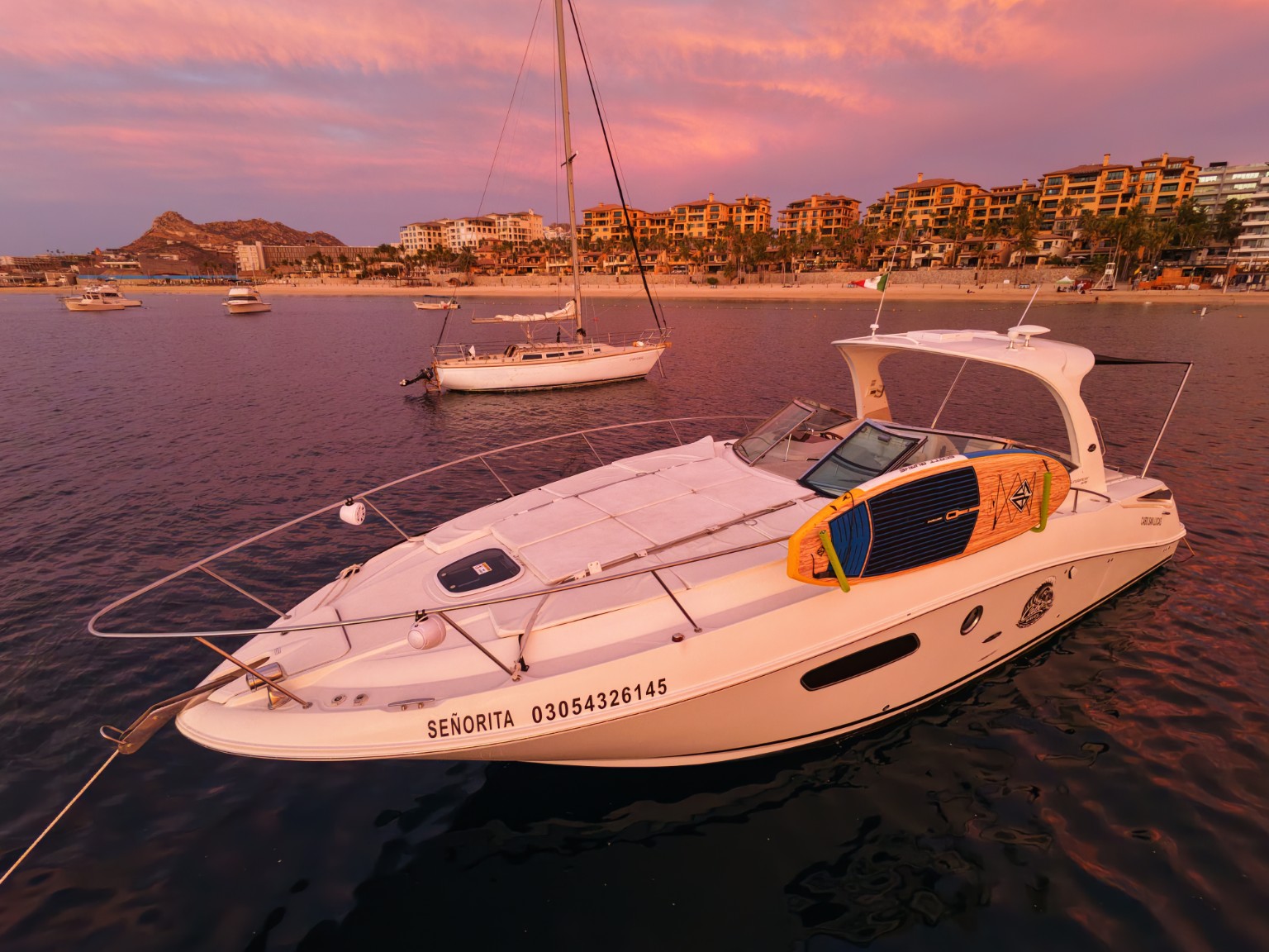 Aerial view of Señorita moored off Médano Beach under a pink sunset sky